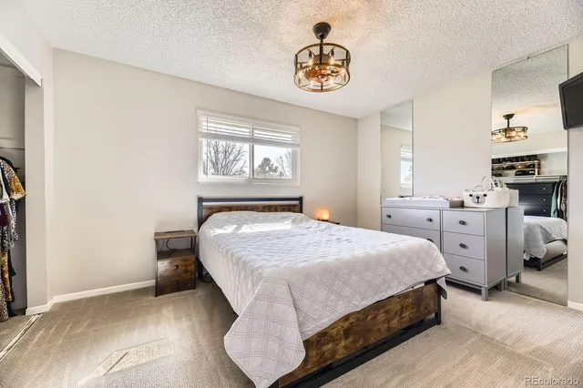 a bedroom with a bed and a chandelier