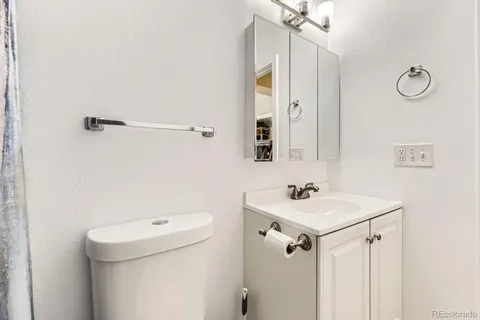 a bathroom with a sink a toilet and a mirror