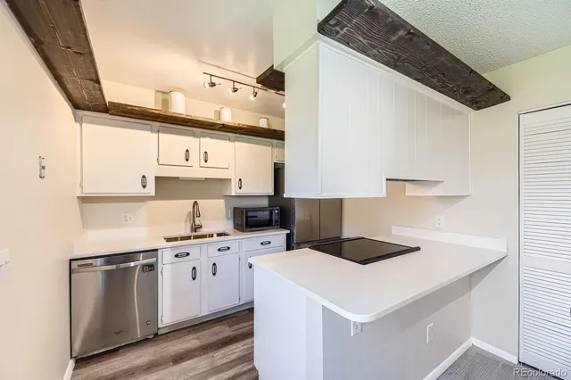a kitchen with a sink a stove and cabinets
