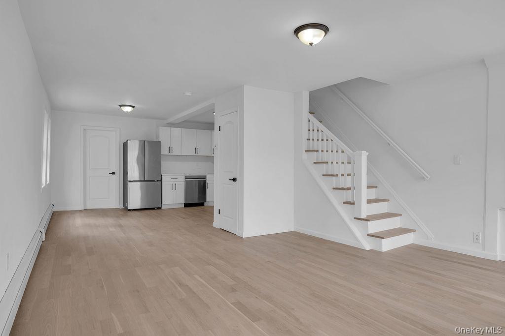 173-62 103rd Road Queens, NY 11433 - Photo 3 of 23 an empty room with wooden floor and entryway