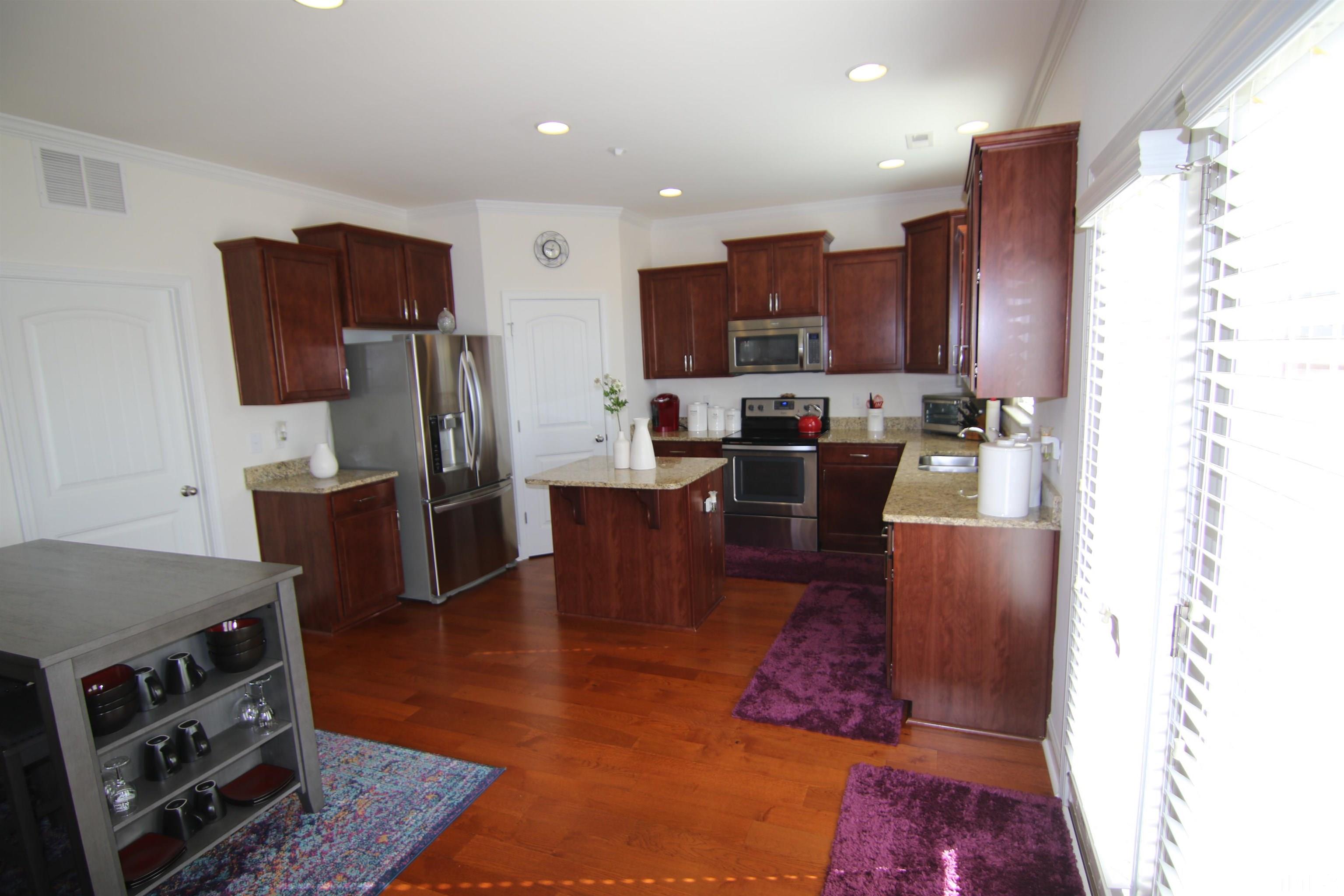 3216 Revelation Street Raleigh, NC 27610 - Photo 3 of 23 a kitchen with stainless steel appliances granite countertop a refrigerator stove microwave and sink