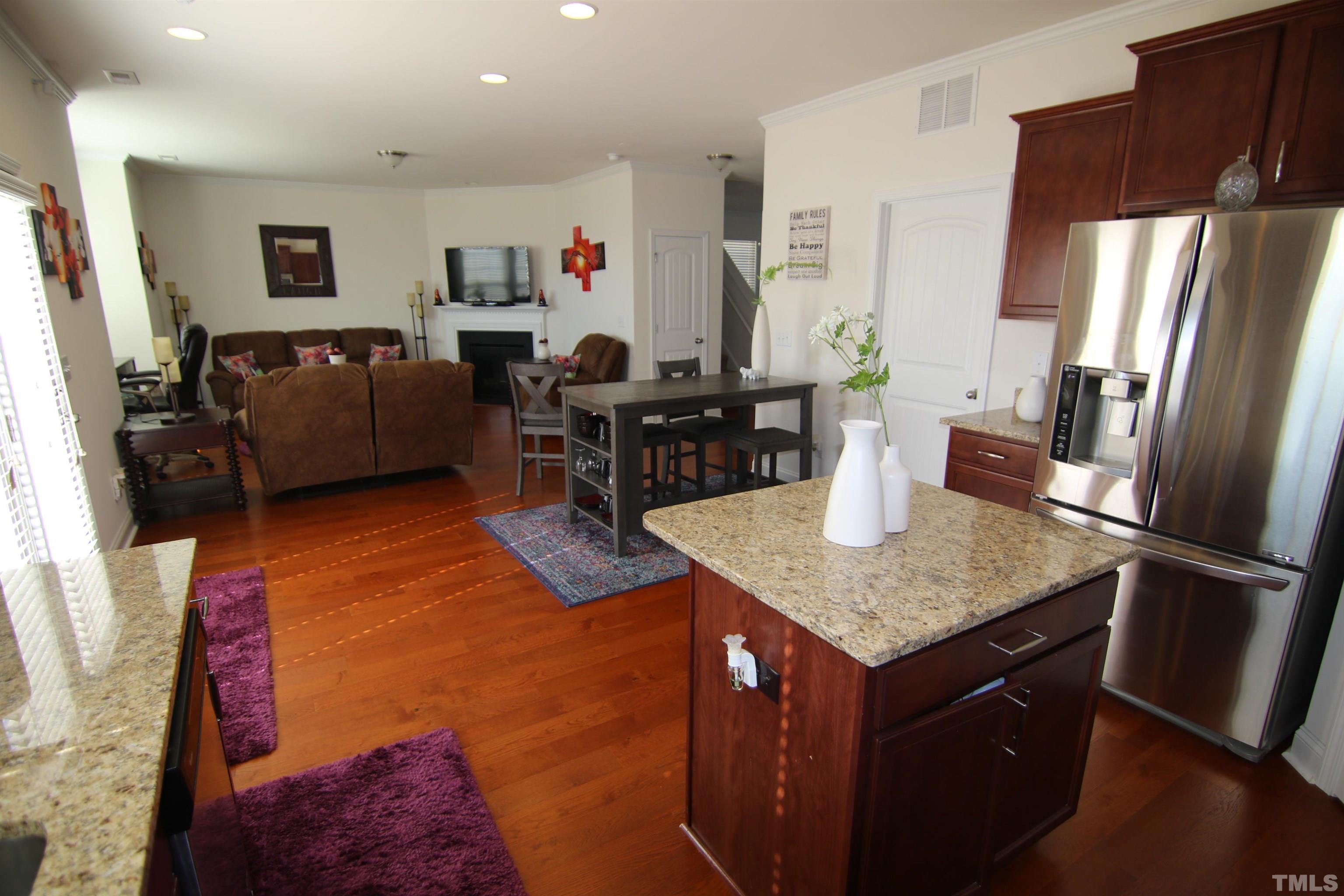 3216 Revelation Street Raleigh, NC 27610 - Photo 4 of 23 a kitchen with stainless steel appliances granite countertop a refrigerator a stove a sink a dining table and chairs