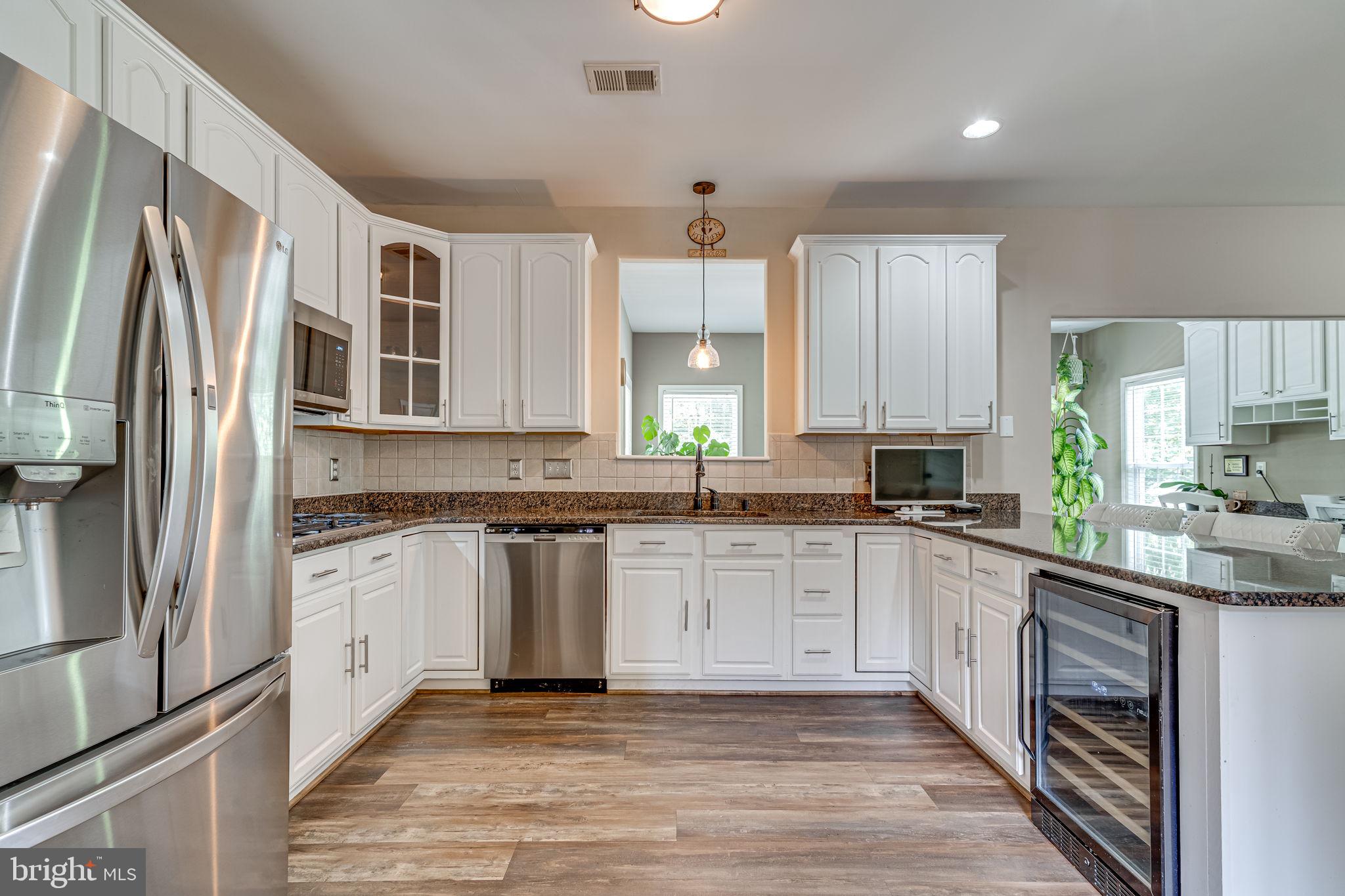 6904 North Stuart Road King George, VA 22485 - Photo 11 of 47 a kitchen with stainless steel appliances granite countertop a refrigerator sink and cabinets