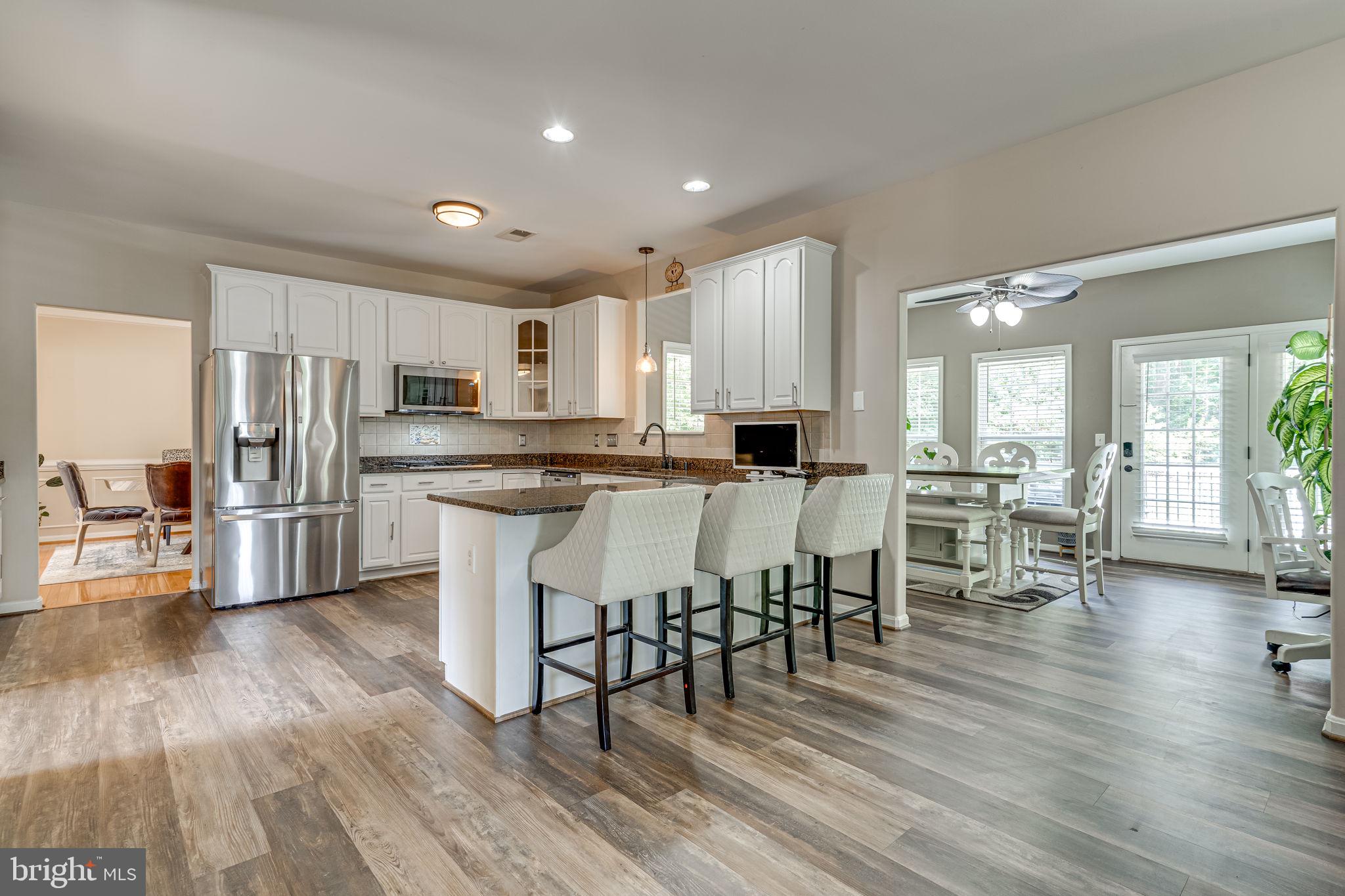 6904 North Stuart Road King George, VA 22485 - Photo 2 of 47 a kitchen with stainless steel appliances a dining table chairs refrigerator and cabinets