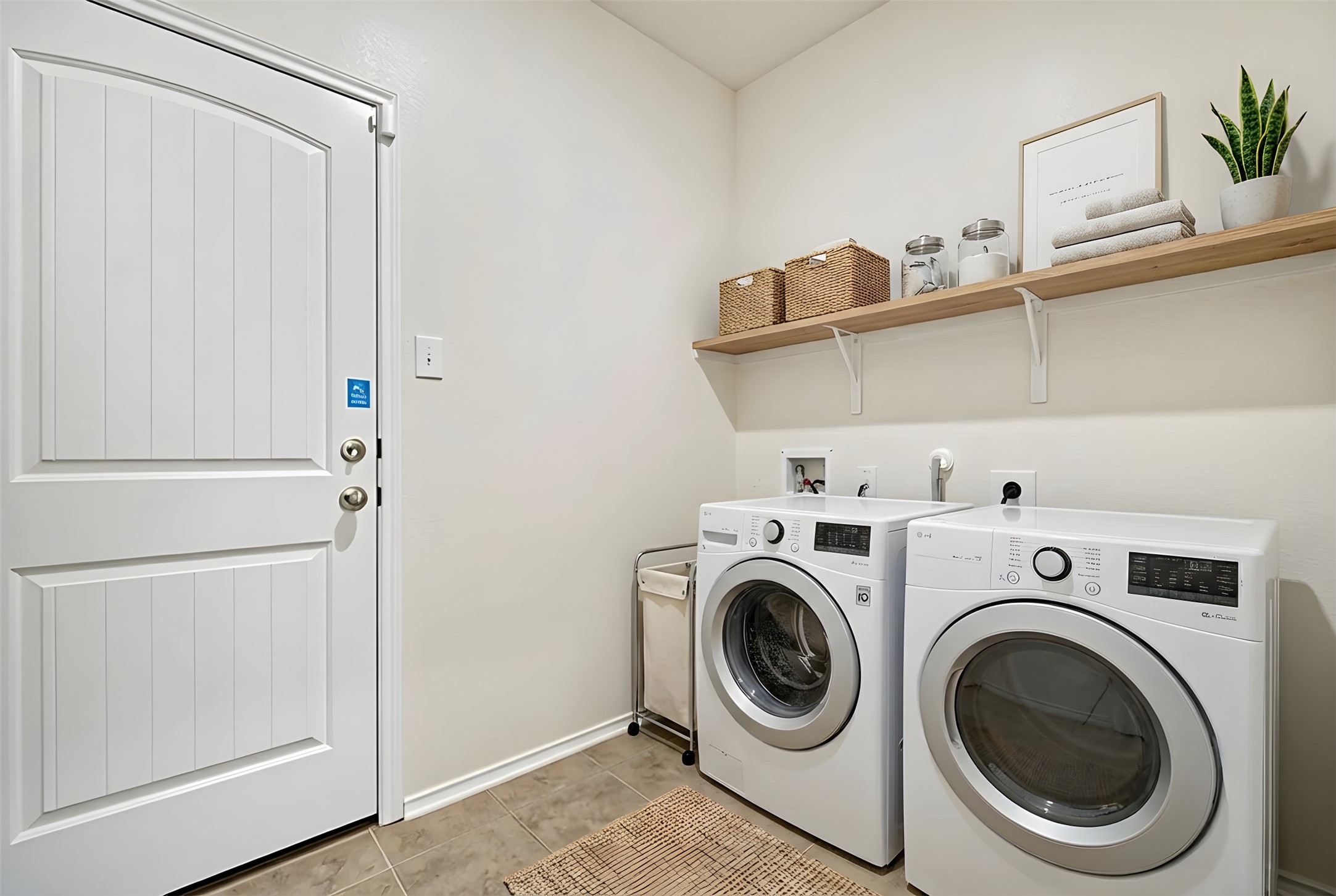 13917 Inaugural Street Manor, TX 78653 - Photo 14 of 39 Washroom featuring washing machine and dryer and light tile patterned flooring