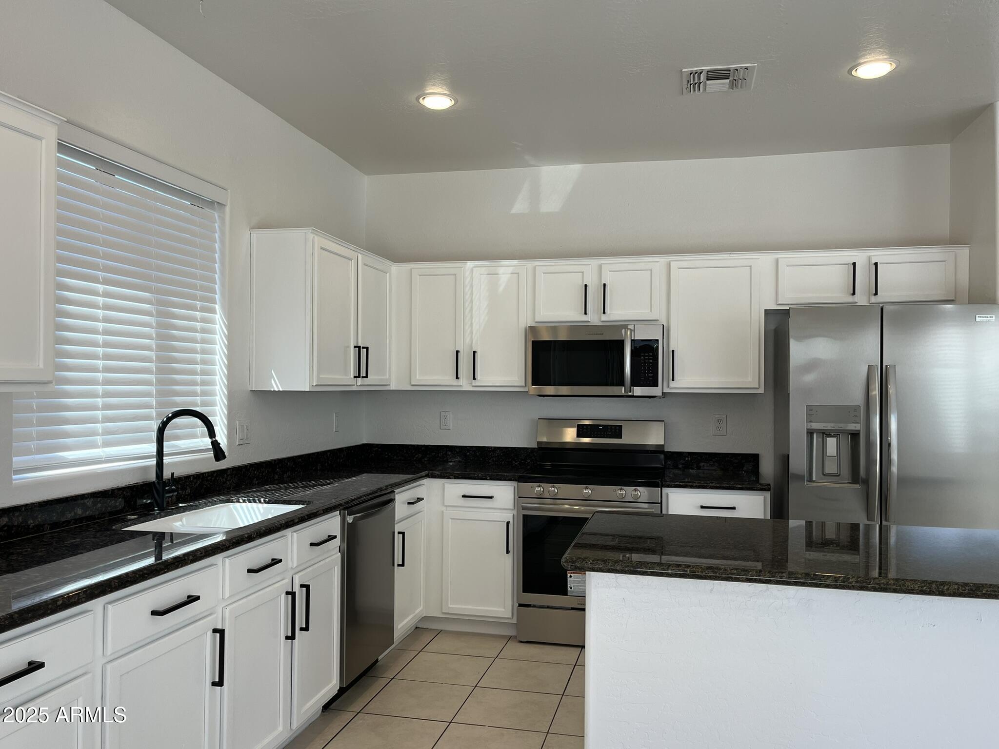 2319 West Alta Vista Road Phoenix, AZ 85041 - Photo 12 of 43 a kitchen with stainless steel appliances granite countertop a sink a stove a refrigerator and cabinets