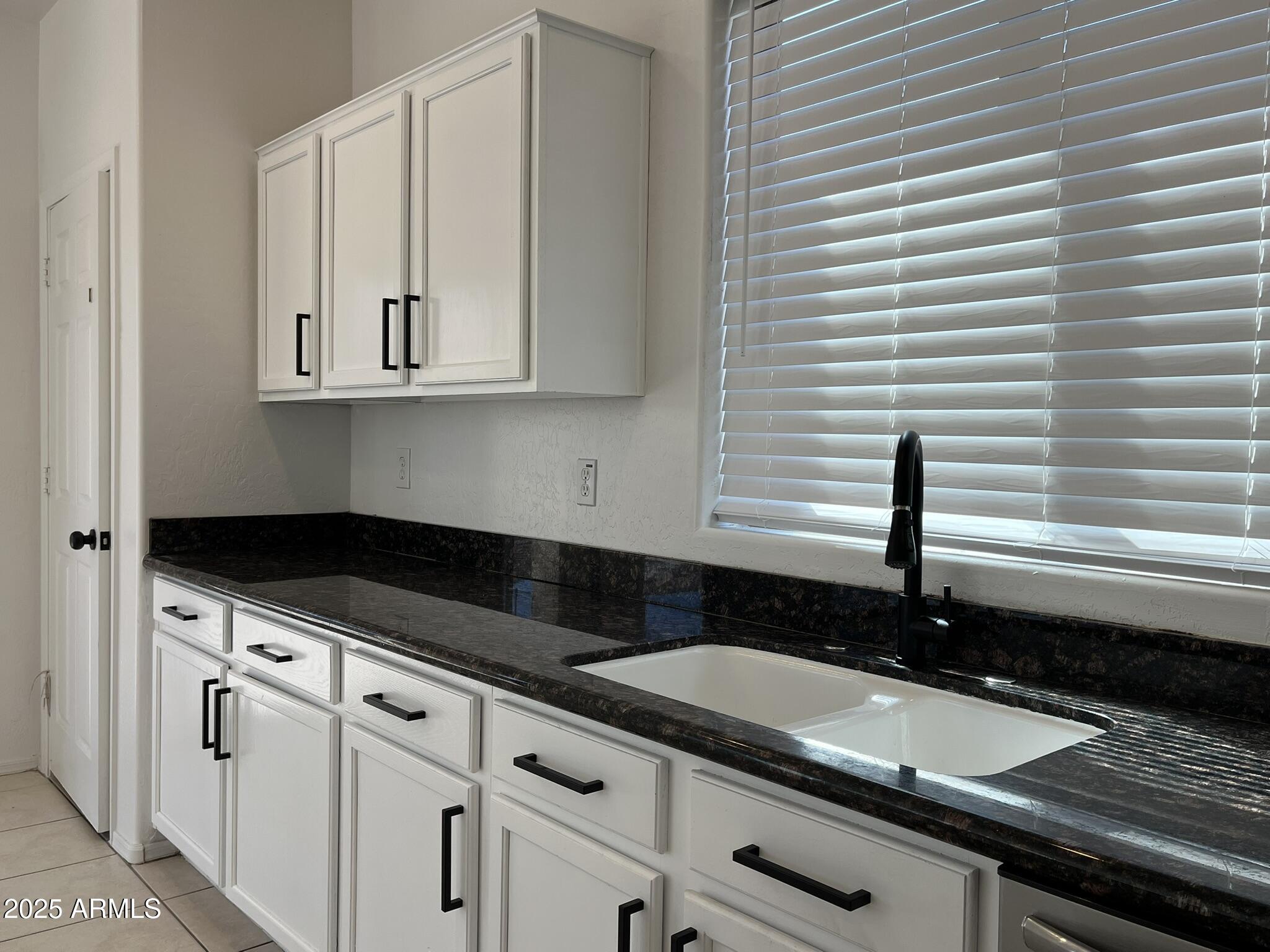 2319 West Alta Vista Road Phoenix, AZ 85041 - Photo 13 of 43 a kitchen with granite countertop white cabinets and sink