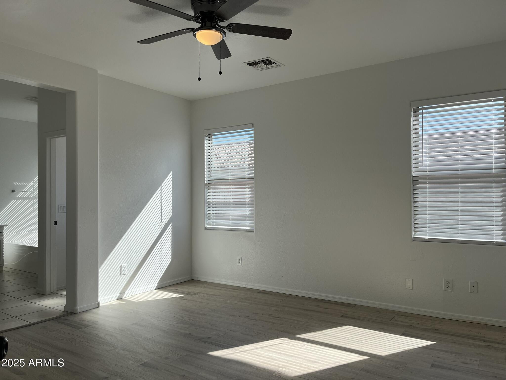 2319 West Alta Vista Road Phoenix, AZ 85041 - Photo 18 of 43 a view of an empty room with wooden floor and a window