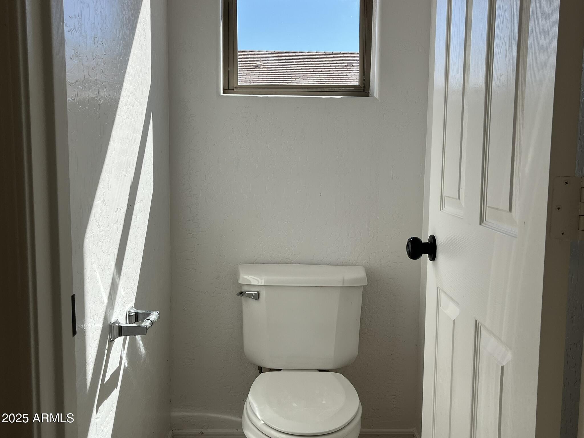 2319 West Alta Vista Road Phoenix, AZ 85041 - Photo 25 of 43 a white toilet sitting next to a window