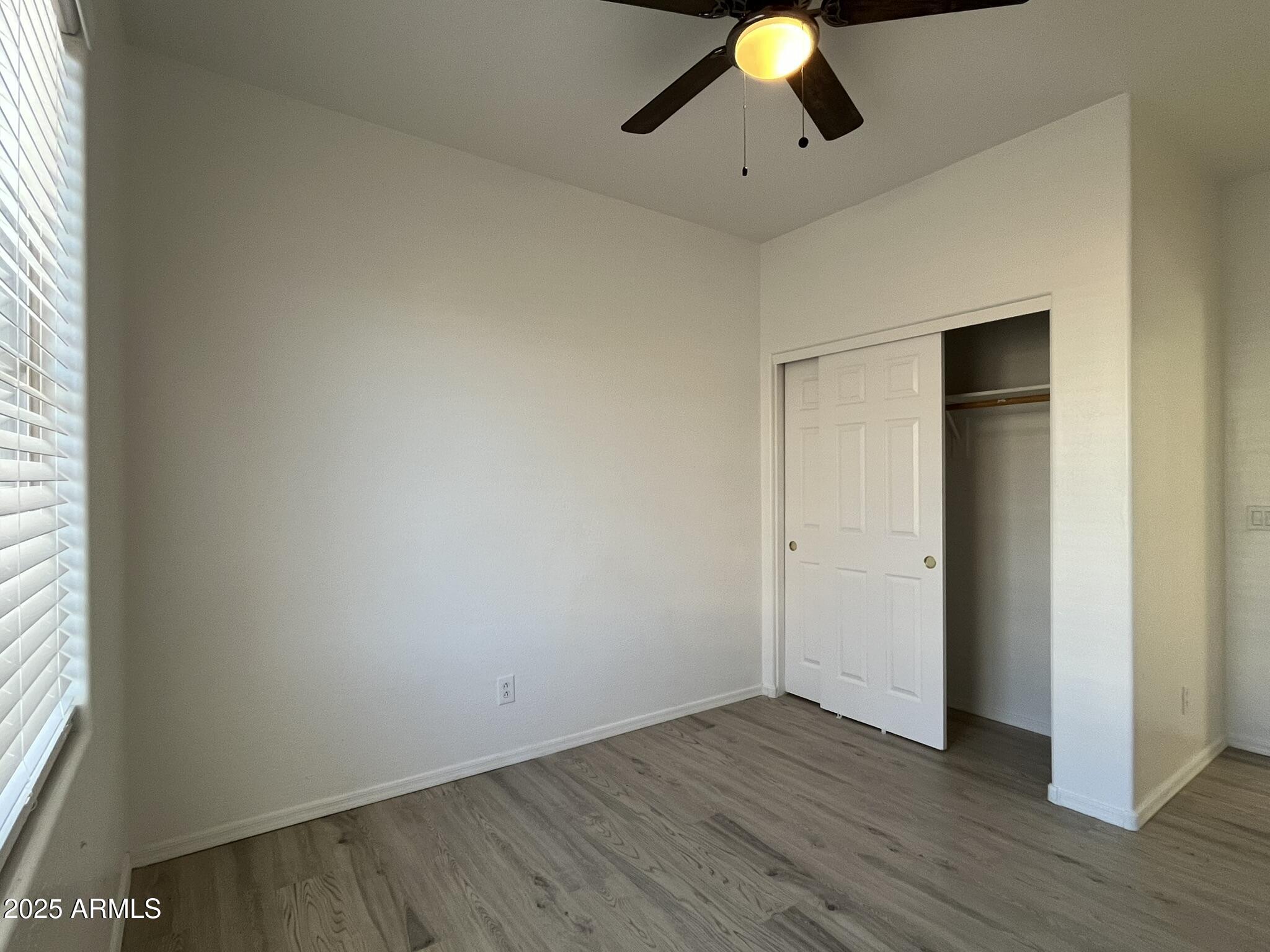 2319 West Alta Vista Road Phoenix, AZ 85041 - Photo 27 of 43 an empty room with wooden floor and windows
