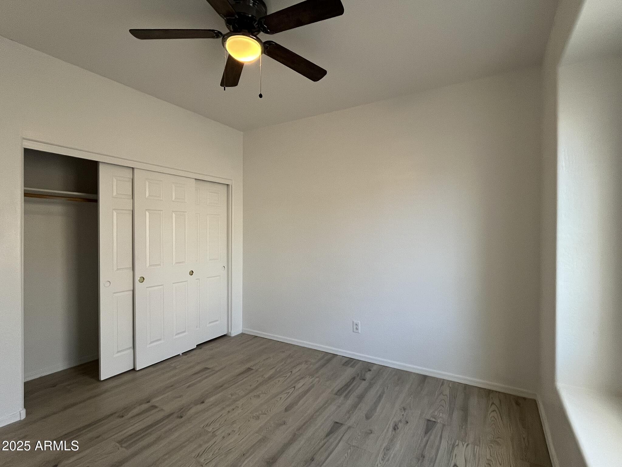 2319 West Alta Vista Road Phoenix, AZ 85041 - Photo 29 of 43 an empty room with wooden floor and windows