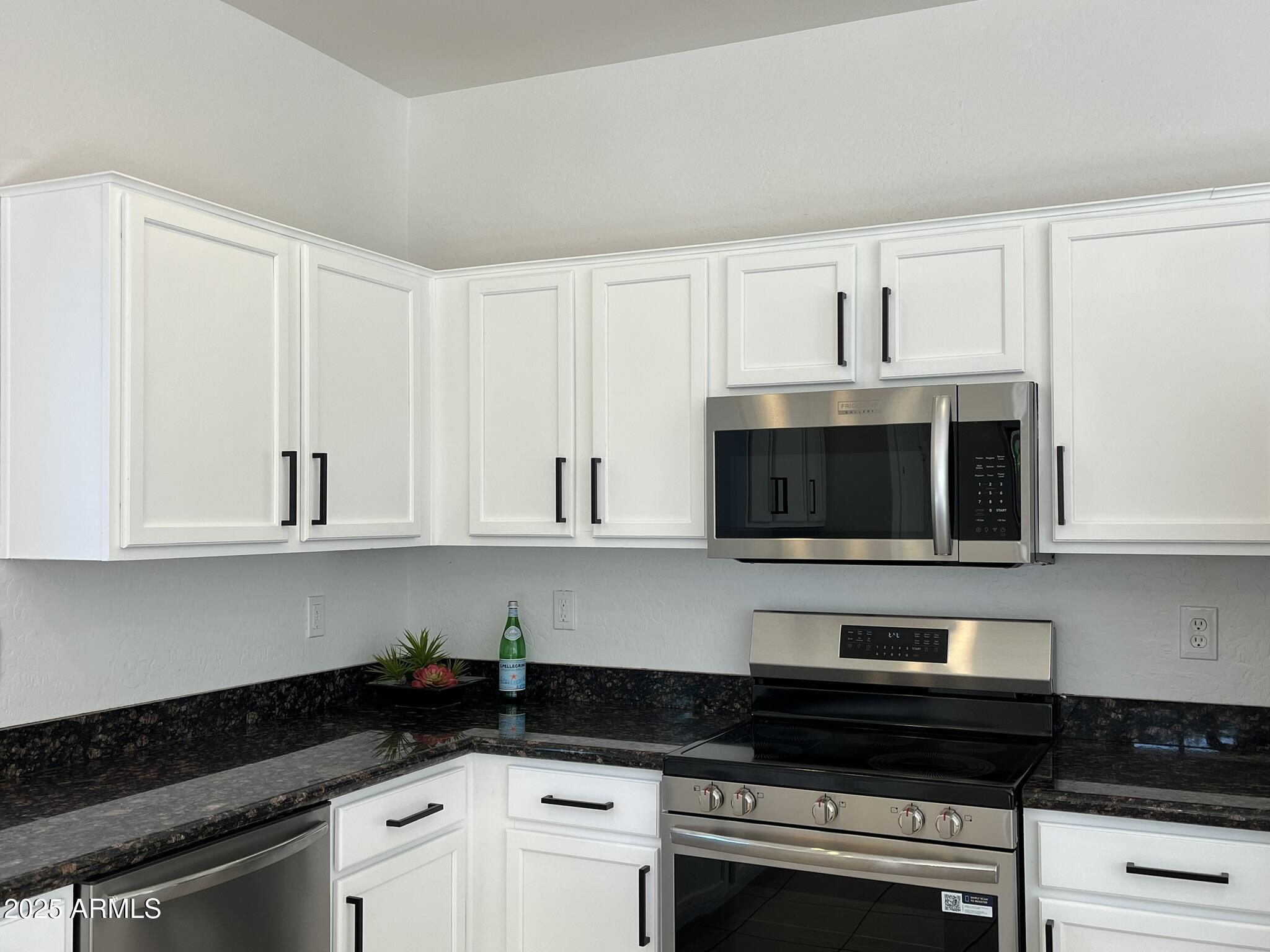 2319 West Alta Vista Road Phoenix, AZ 85041 - Photo 9 of 43 a kitchen with stainless steel appliances granite countertop white cabinets a stove a sink and dishwasher