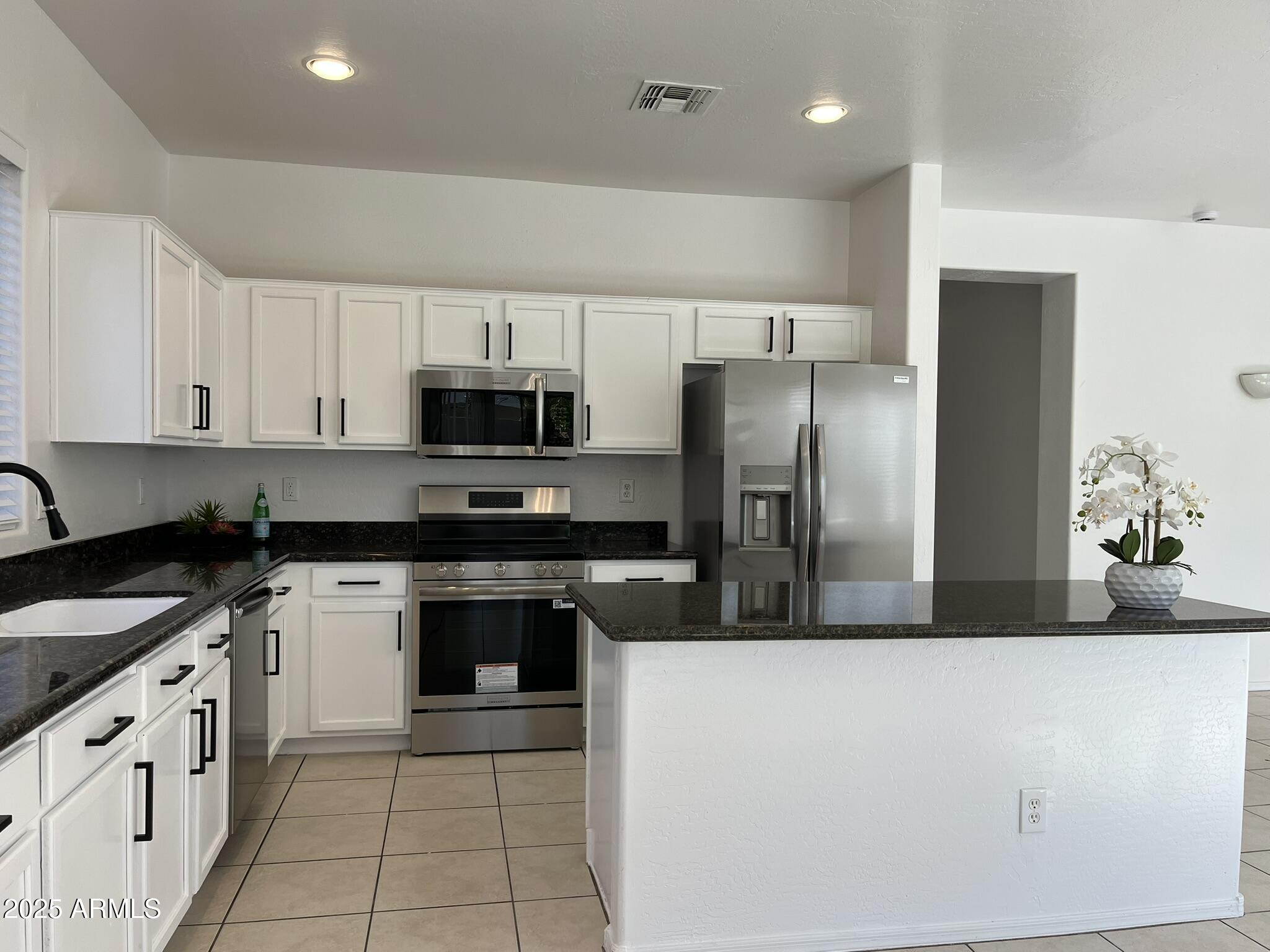2319 West Alta Vista Road Phoenix, AZ 85041 - Photo 10 of 43 a kitchen with stainless steel appliances granite countertop a stove a sink and a refrigerator