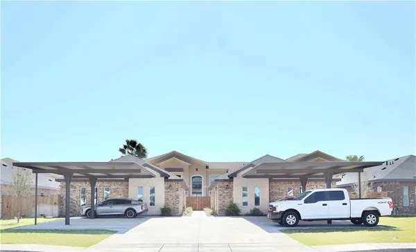 a front view of residential houses with yard and parking space