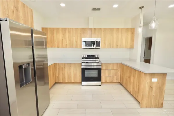 a kitchen with stainless steel appliances a refrigerator and a stove