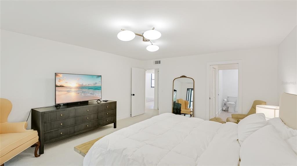 303 Springdale Drive, Unit 303 Bradenton, FL 34210 - Photo 15 of 23 a bedroom with a bed and a chandelier