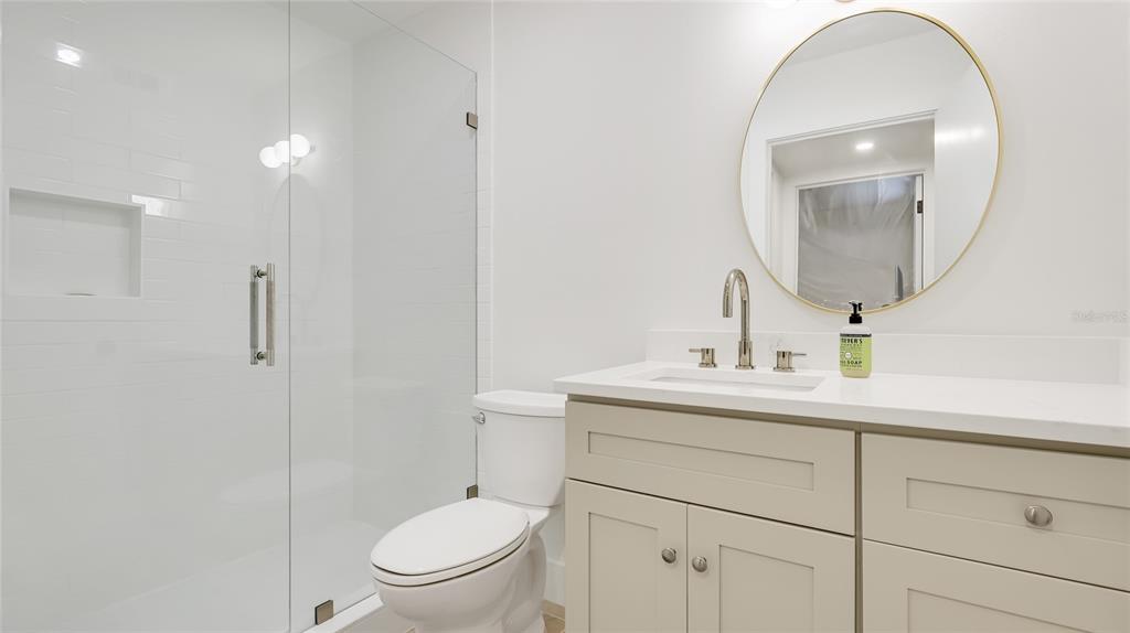 303 Springdale Drive, Unit 303 Bradenton, FL 34210 - Photo 21 of 23 a bathroom with a toilet a sink and mirror