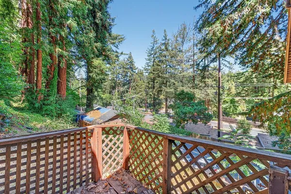 a view of outdoor house with wooden stairs and potted plants