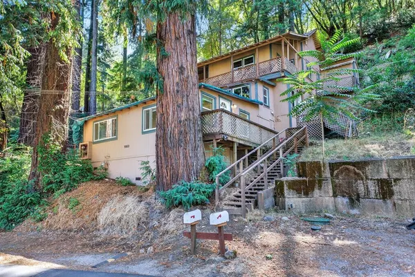 a front view of a house with a tree