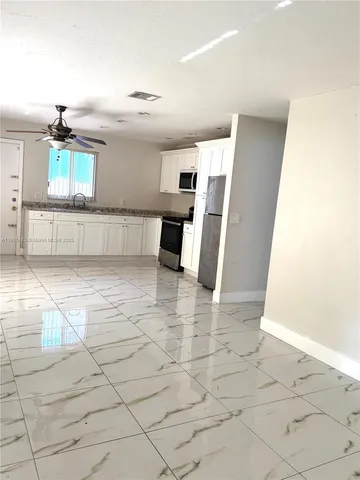 a view of a kitchen with furniture and a refrigerator