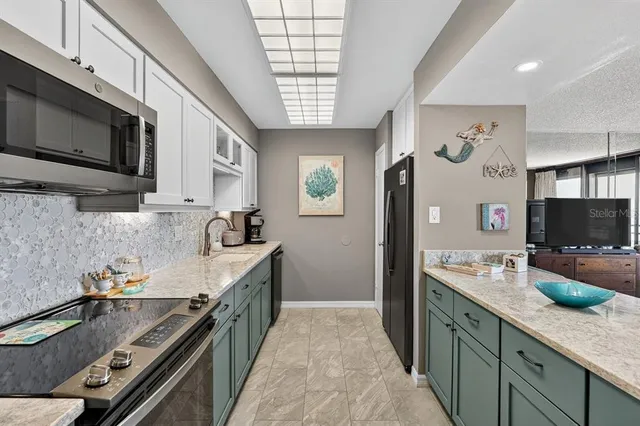 a large kitchen with stainless steel appliances granite countertop a large stove a sink dishwasher and microwave with wooden floor