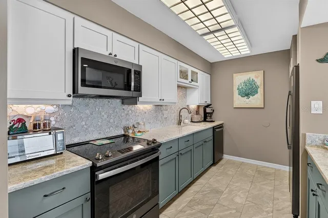 a kitchen with stainless steel appliances granite countertop a stove microwave and sink