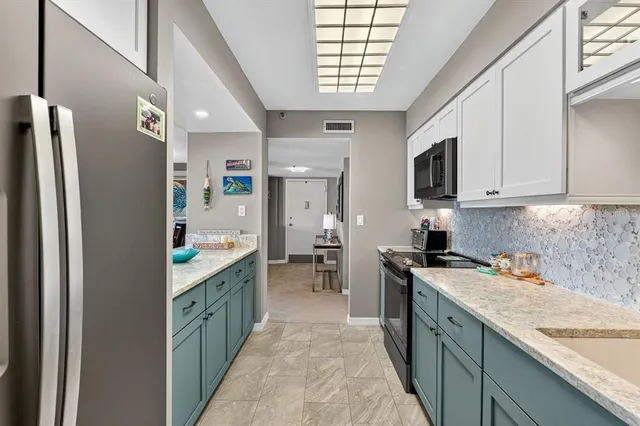 a kitchen with stainless steel appliances granite countertop a refrigerator and a stove top oven
