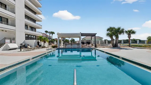 a view of a swimming pool with a bench and tables