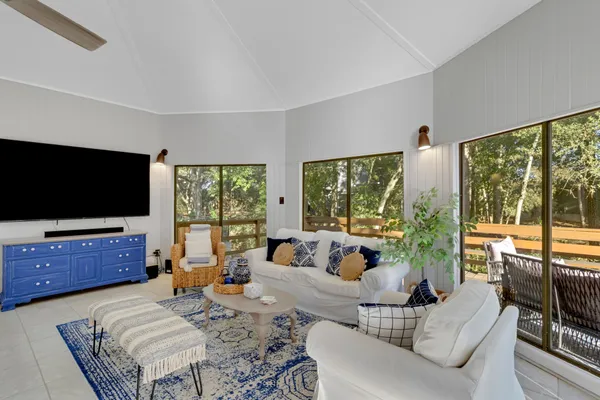 a living room with furniture a flat screen tv and a large window