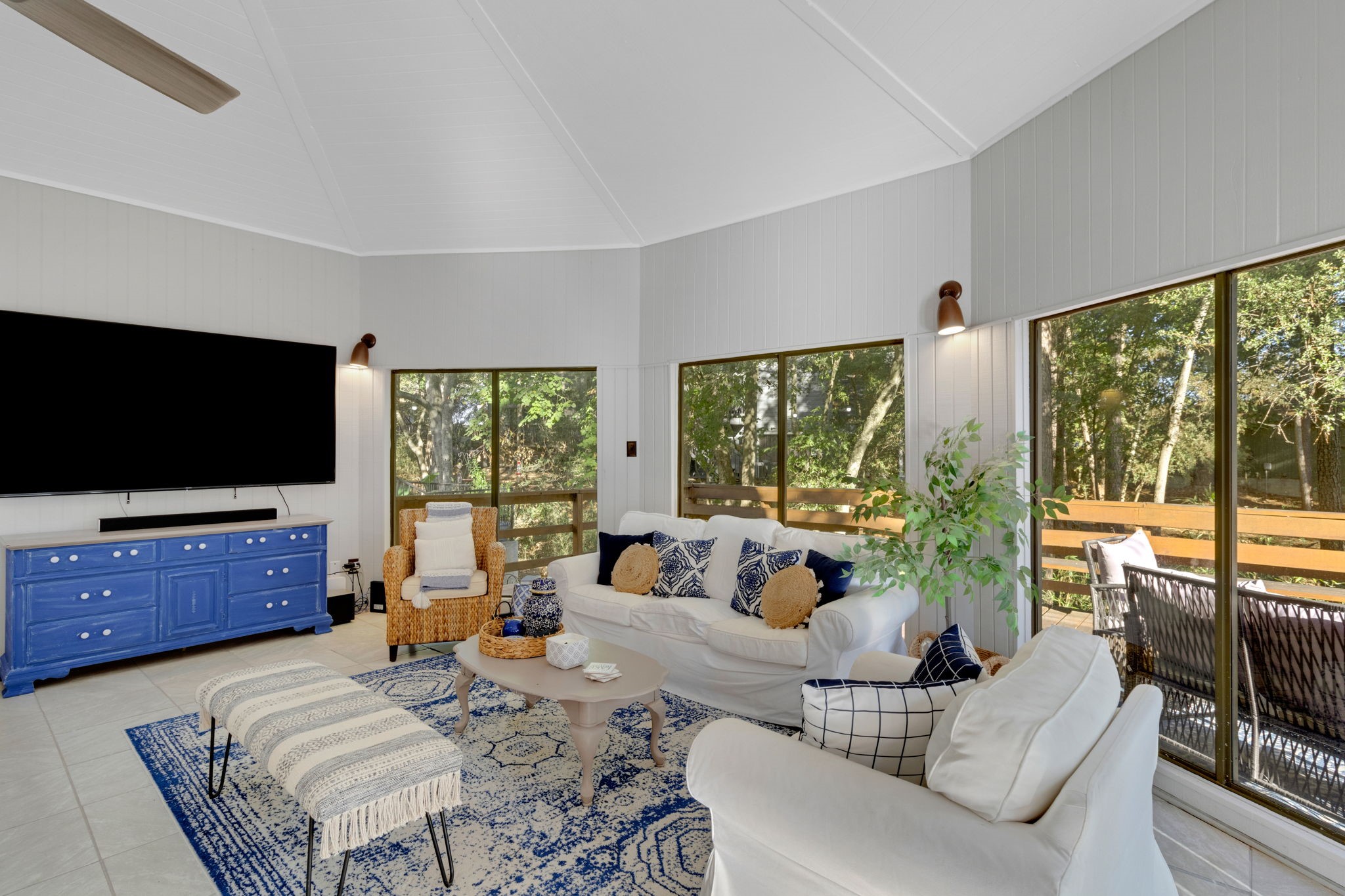 90 Harbour Lane Coldspring, TX 77331 - Photo 1 of 40 Comfortable living area with wraparound windows showcasing peaceful wooded views.