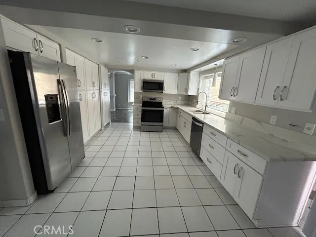 a large kitchen with a stove a refrigerator and a sink