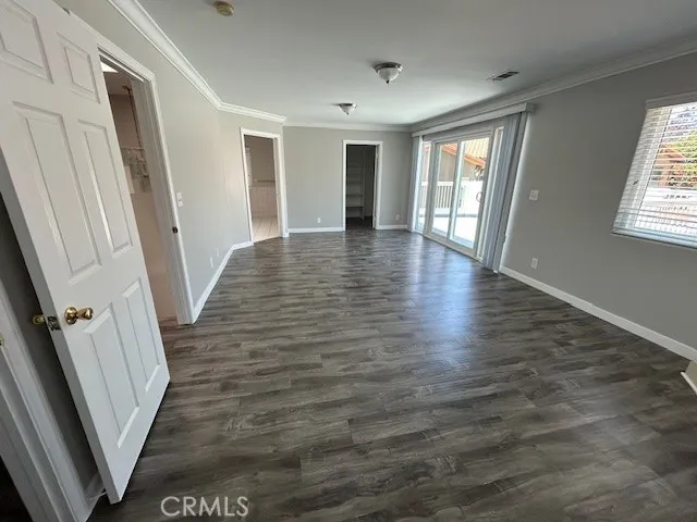 a view of an empty room with wooden floor and stairs