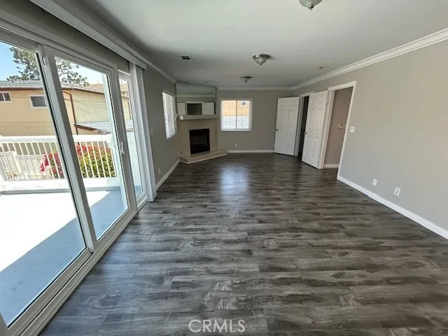 a view of empty room with wooden floor and floor to ceiling window