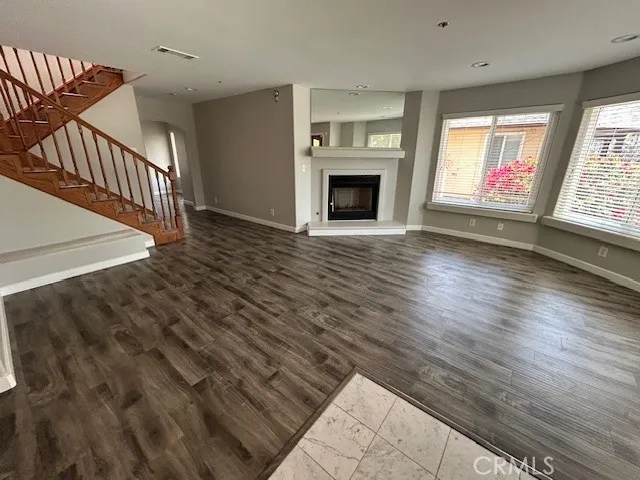 wooden floor fireplace and windows in an empty room