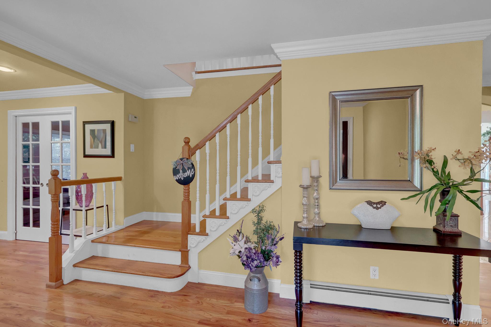 15 Stillwater Road Nissequogue, NY 11780 - Photo 4 of 43 Hardwood flooring throughout the entry, a staircase with wood newel posts and handrails, and white balusters