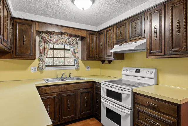 a kitchen with a sink stove and microwave