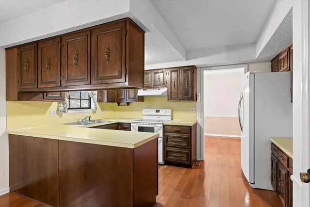 a kitchen with stainless steel appliances granite countertop a refrigerator a sink and a stove