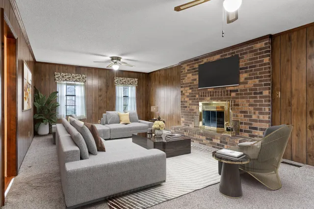 a living room with furniture a flat screen tv and a fireplace