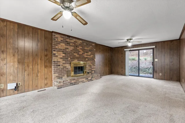 a view of an empty room with a fireplace and a window