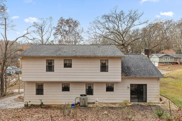 a front view of a house with a tree