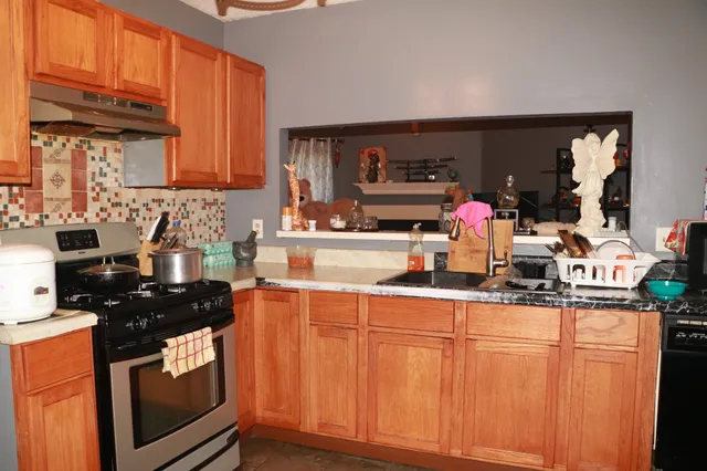 a kitchen with stainless steel appliances granite countertop a stove a sink and a microwave
