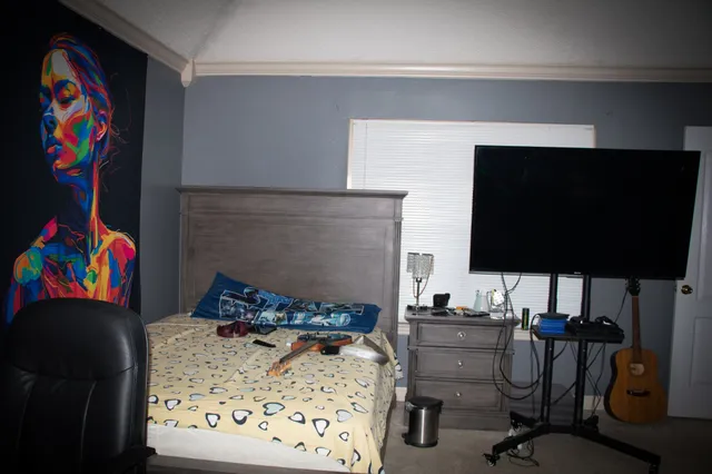 a bedroom with a bed and a flat screen tv