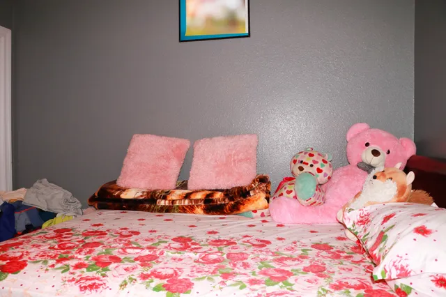 a bedroom with a bed and a lamp on dresser