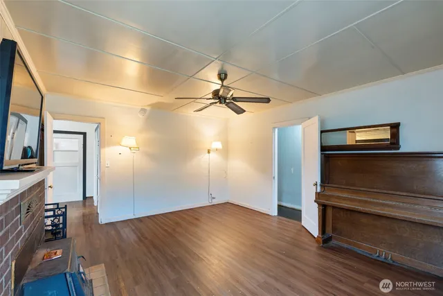 a view of a livingroom with wooden floor and a ceiling fan