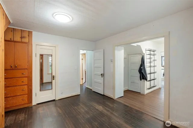 an empty room with wooden floor and closet