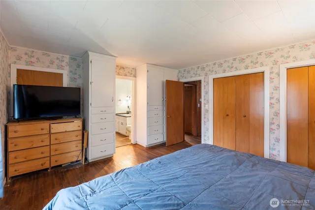 a bedroom with a bed and flat screen tv