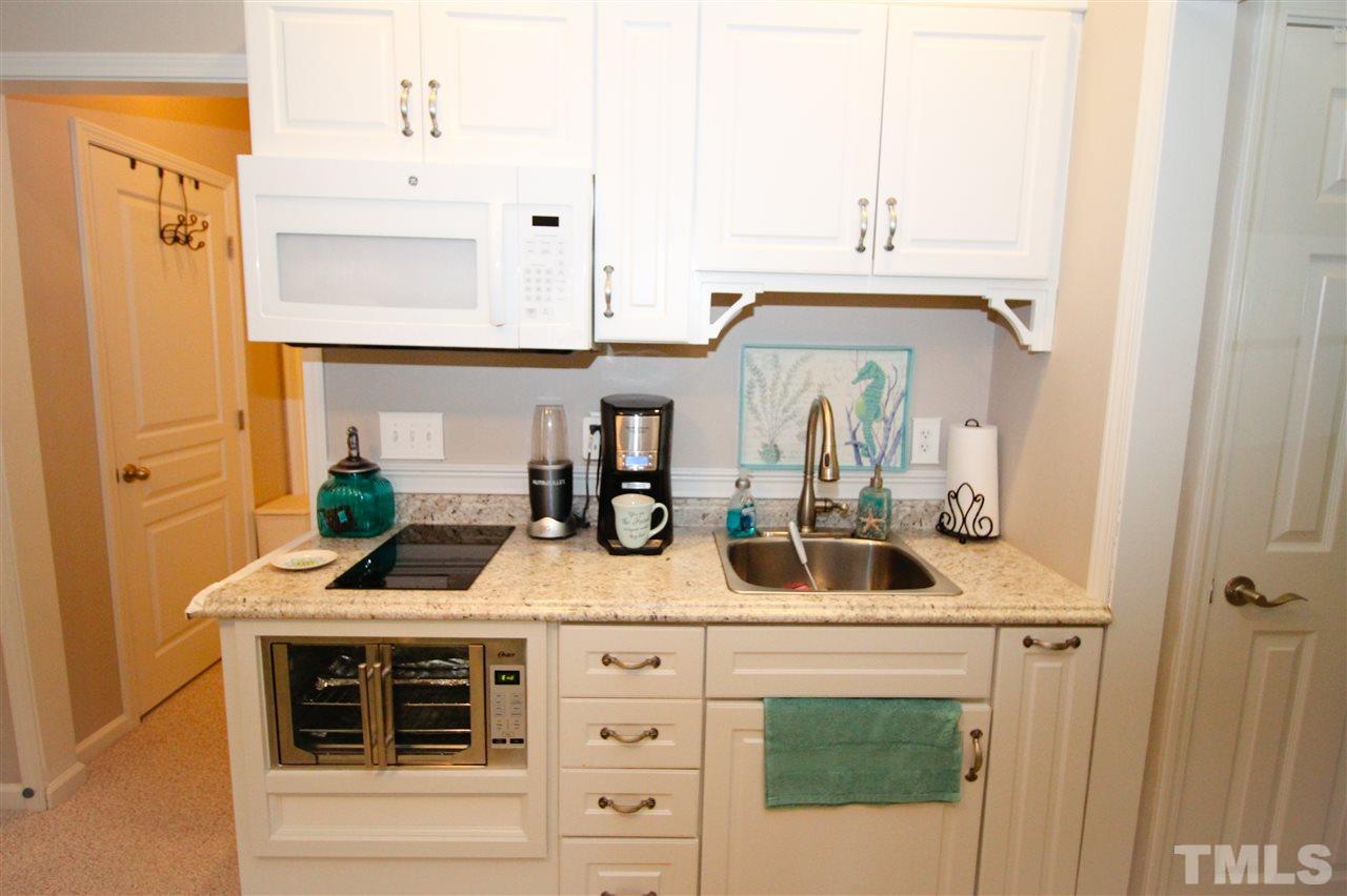 7757 Winners Edge Street Raleigh, NC 27617 - Photo 15 of 24 This is the Kitchen area in the lower level! Fully loaded with hot plate cook top, oven, microwave, everything you need to live nestled into this fantastic space!