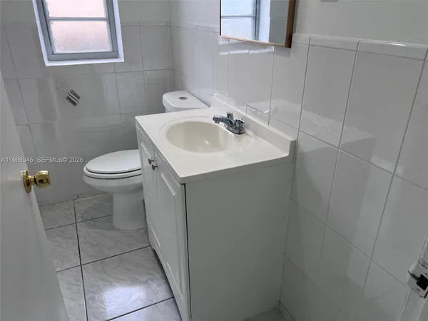 a bath tub sitting next to a white toilet and a shower