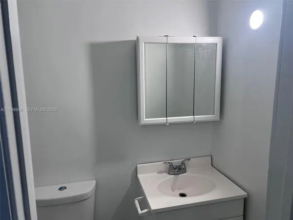 a white toilet sitting next to a bathroom sink