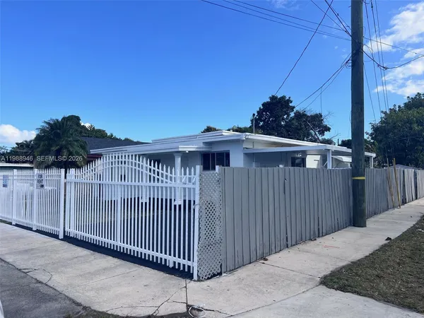 a view of a house with a wooden fence